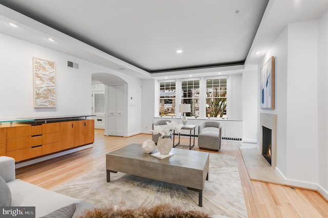 2950 Macomb St NW, Washington, DC 20008 - living area featuring light wood finished floors, arched walkways, a high end fireplace, baseboards, and recessed lighting