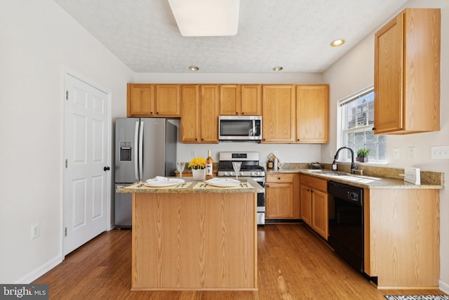 8309 Pigeon Fork Ln, Laurel, MD 20724 - kitchen with appliances with stainless steel finishes, wood finished floors, a textured ceiling, a kitchen island, and recessed lighting