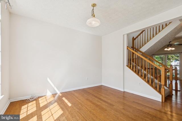 8309 Pigeon Fork Ln, Laurel, MD 20724 - spare room featuring wood finished floors, stairway, and a textured ceiling