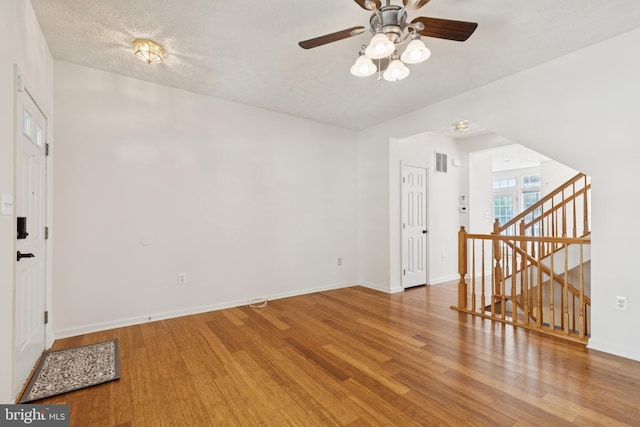 8309 Pigeon Fork Ln, Laurel, MD 20724 - unfurnished room with wood finished floors, ceiling fan, and stairs