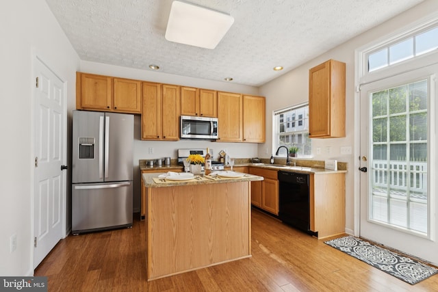 8309 Pigeon Fork Ln, Laurel, MD 20724 - kitchen with appliances with stainless steel finishes, a textured ceiling, wood finished floors, light countertops, and a kitchen island