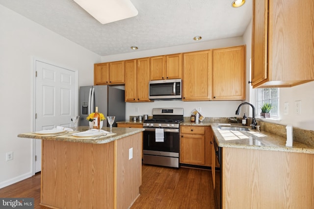 8309 Pigeon Fork Ln, Laurel, MD 20724 - kitchen with appliances with stainless steel finishes, dark wood-style floors, a kitchen island, a textured ceiling, and light stone countertops