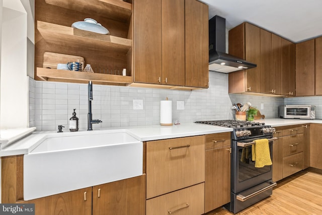 1850 Irving St NW, Washington, DC 20010 - kitchen with wall chimney range hood, black gas range, open shelves, decorative backsplash, and light wood-type flooring