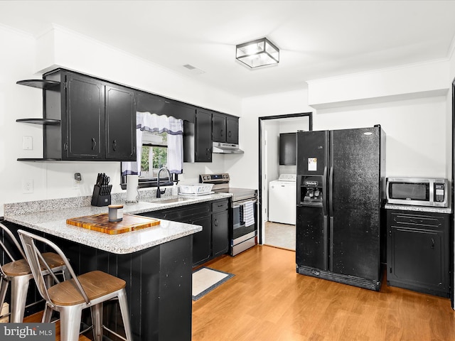 213 S 6th St, Denton, MD 21629 - kitchen featuring appliances with stainless steel finishes, dark cabinets, washer / dryer, a peninsula, and open shelves
