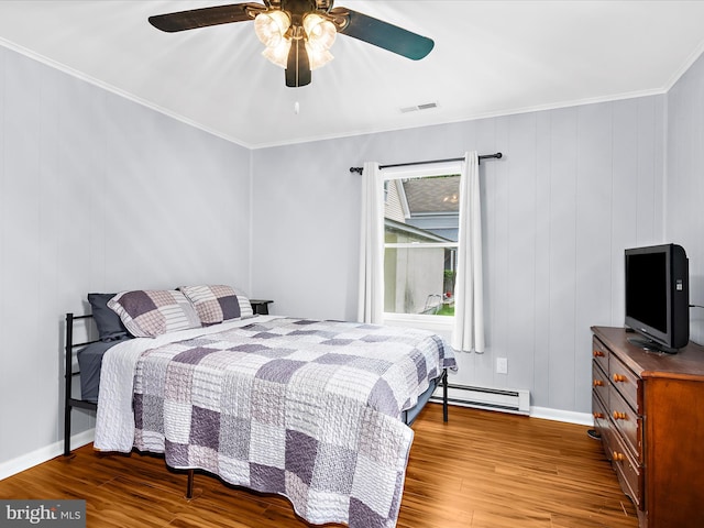 213 S 6th St, Denton, MD 21629 - bedroom with wood finished floors, baseboard heating, crown molding, and ceiling fan