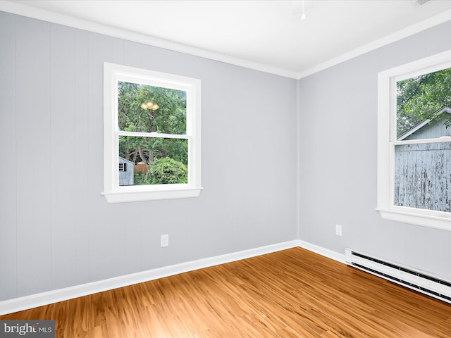 213 S 6th St, Denton, MD 21629 - empty room with a baseboard heating unit, wood finished floors, healthy amount of natural light, and crown molding
