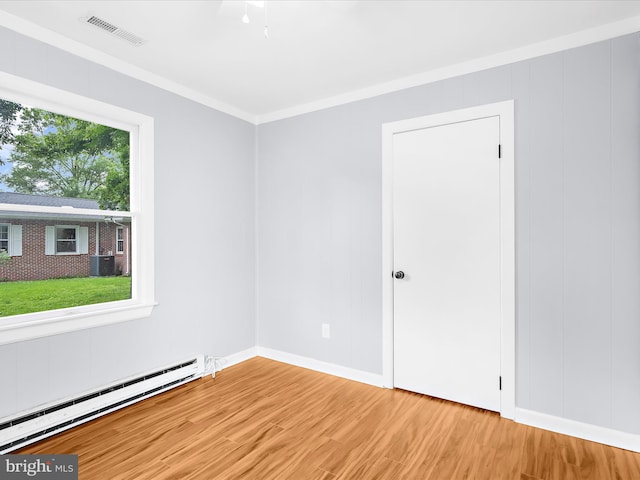 213 S 6th St, Denton, MD 21629 - unfurnished room with a baseboard heating unit, light wood-style floors, and crown molding