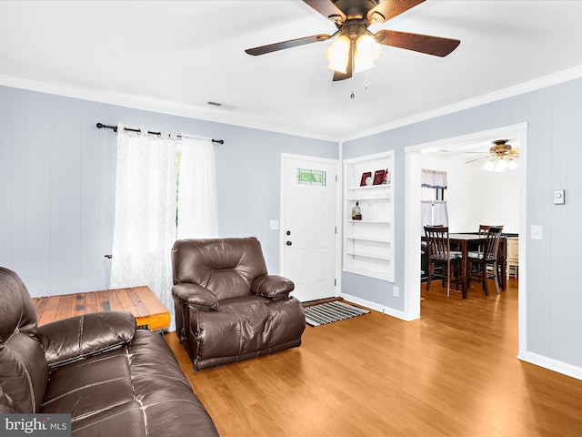 213 S 6th St, Denton, MD 21629 - living area with wood finished floors, crown molding, a ceiling fan, and built in features