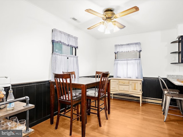 213 S 6th St, Denton, MD 21629 - dining space with a ceiling fan, light wood-style flooring, crown molding, and a wainscoted wall