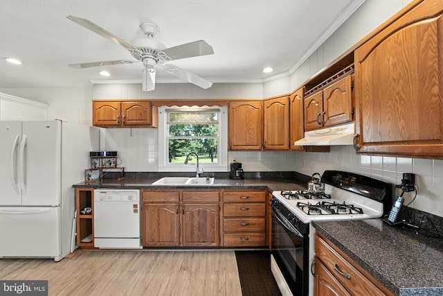 kitchen with white appliances, under cabinet range hood, brown cabinetry, light wood-type flooring, and backsplash