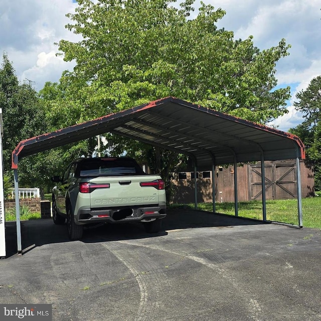 view of vehicle parking featuring a detached carport and driveway