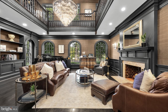 13300 Manor Stone Dr, Darnestown, MD 20874 - living room featuring ornamental molding, a high end fireplace, a decorative wall, a towering ceiling, and wood finished floors