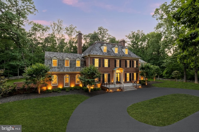 13300 Manor Stone Dr, Darnestown, MD 20874 - georgian-style home featuring a high end roof, curved driveway, brick siding, a chimney, and a front yard