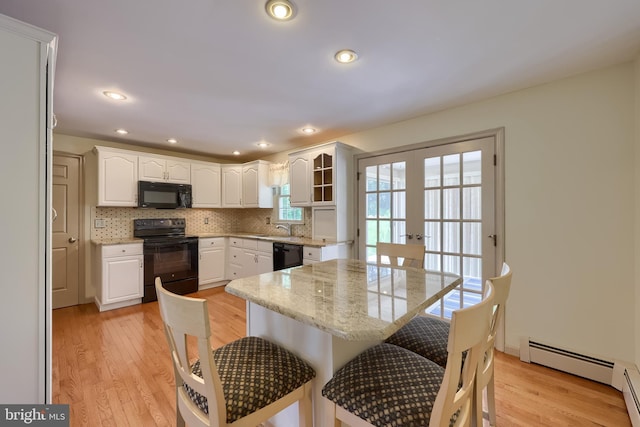 1549 Willoughby Cir, Manheim, PA 17545 - kitchen featuring black appliances, a breakfast bar, light wood-style flooring, white cabinets, and recessed lighting