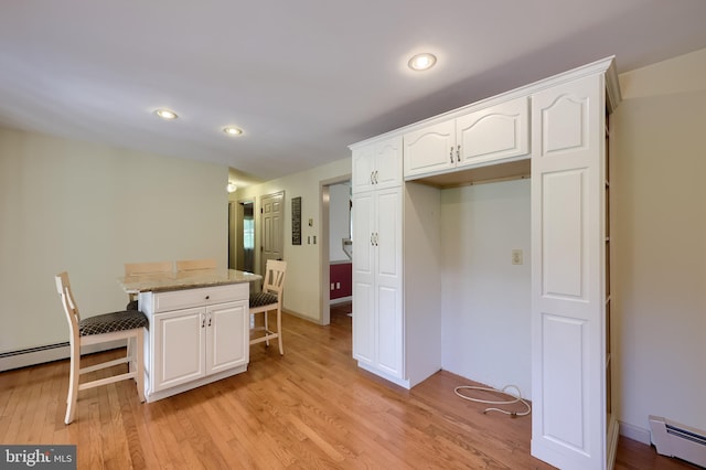 1549 Willoughby Cir, Manheim, PA 17545 - kitchen featuring a baseboard heating unit, a breakfast bar, white cabinets, light wood-type flooring, and recessed lighting