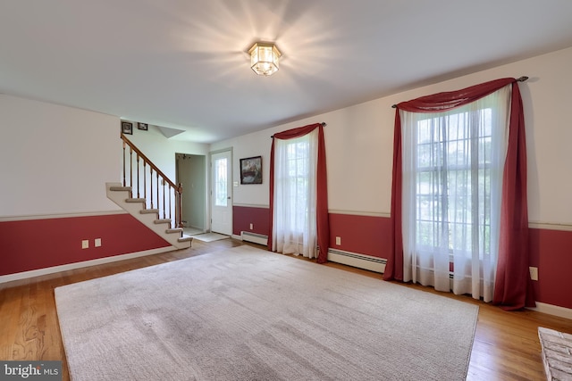 1549 Willoughby Cir, Manheim, PA 17545 - unfurnished living room featuring a baseboard radiator, stairway, and wood finished floors