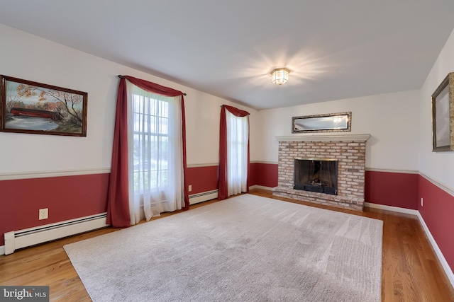 1549 Willoughby Cir, Manheim, PA 17545 - unfurnished living room featuring baseboard heating, wood finished floors, and a brick fireplace