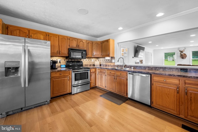 2997 Patapsco Rd, Finksburg, MD 21048 - kitchen featuring stainless steel appliances, a sink, light wood finished floors, brown cabinetry, and ornamental molding