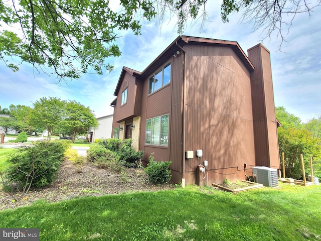 3747 Spring Lake Ln, Owings Mills, MD 21117 - view of home's exterior featuring central air condition unit, a lawn, a chimney, and a vegetable garden