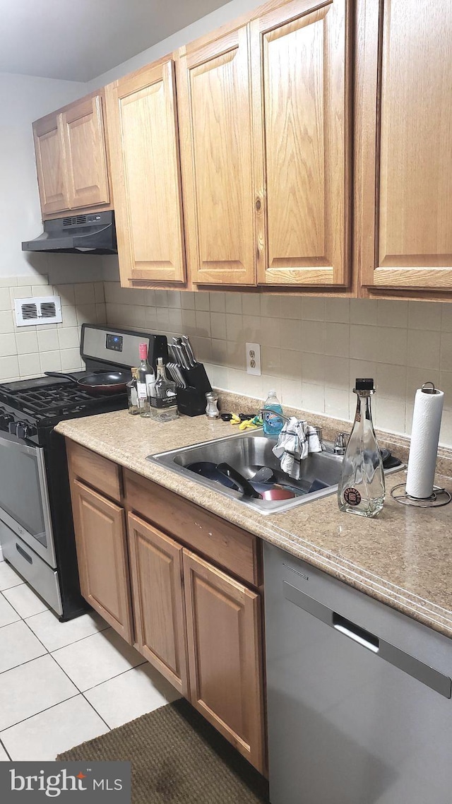 7143 Donnell Pl Unit C, District Heights, MD 20747 - kitchen with appliances with stainless steel finishes, under cabinet range hood, tasteful backsplash, light tile patterned floors, and light countertops