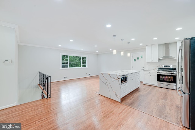 4721 Springbrook Dr, Annandale, VA 22003 - kitchen with appliances with stainless steel finishes, wall chimney range hood, ornamental molding, white cabinetry, and light wood-style floors