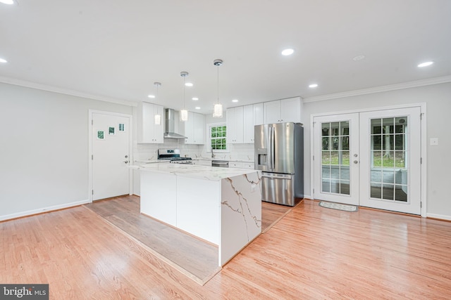4721 Springbrook Dr, Annandale, VA 22003 - kitchen featuring appliances with stainless steel finishes, wall chimney exhaust hood, ornamental molding, light wood-style flooring, and french doors