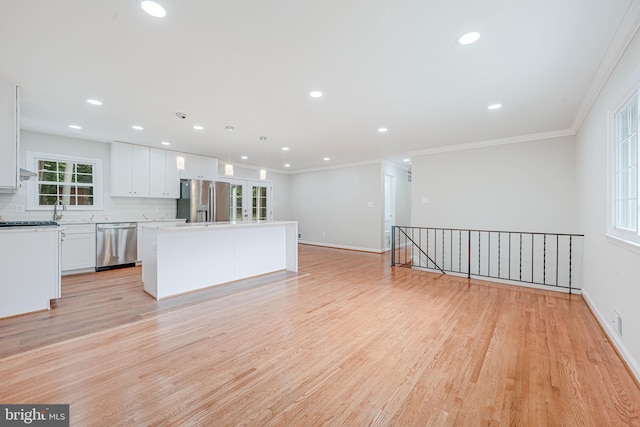4721 Springbrook Dr, Annandale, VA 22003 - kitchen with stainless steel appliances, light wood-type flooring, white cabinetry, a kitchen island, and tasteful backsplash