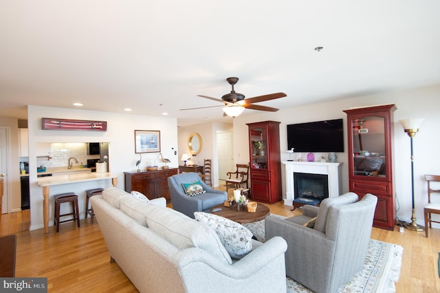 304 Academy St Unit 202, Cambridge, MD 21613 - living room featuring light wood finished floors, a glass covered fireplace, ceiling fan, and recessed lighting