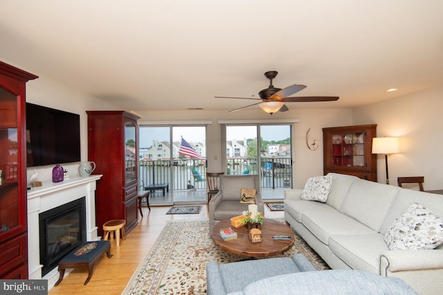 304 Academy St Unit 202, Cambridge, MD 21613 - living room featuring light wood-style flooring, a glass covered fireplace, a ceiling fan, and recessed lighting