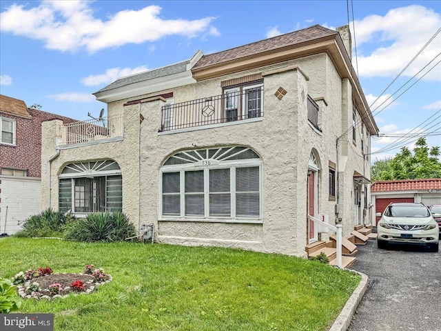 736 Poplar St, Sharon Hill, PA 19079 - view of front of property featuring a balcony, stucco siding, entry steps, and a front yard
