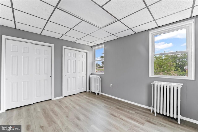 736 Poplar St, Sharon Hill, PA 19079 - unfurnished bedroom featuring radiator heating unit, two closets, a drop ceiling, wood finished floors, and baseboards