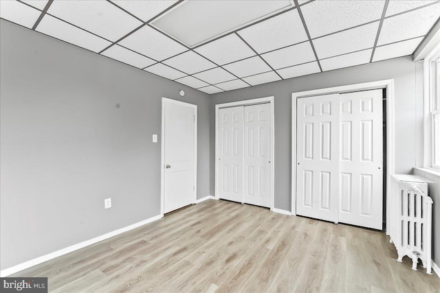 736 Poplar St, Sharon Hill, PA 19079 - unfurnished bedroom with radiator, two closets, a drop ceiling, light wood-style flooring, and baseboards