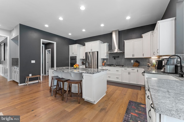 80 Shackelford Well Rd, Fredericksburg, VA 22406 - kitchen featuring appliances with stainless steel finishes, wall chimney range hood, light wood finished floors, white cabinets, and recessed lighting