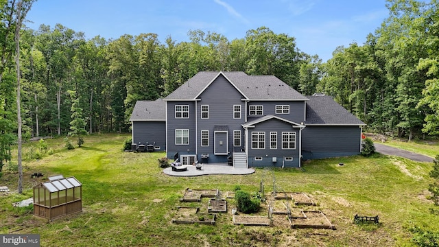 80 Shackelford Well Rd, Fredericksburg, VA 22406 - back of property with a vegetable garden, a lawn, a shingled roof, and a patio