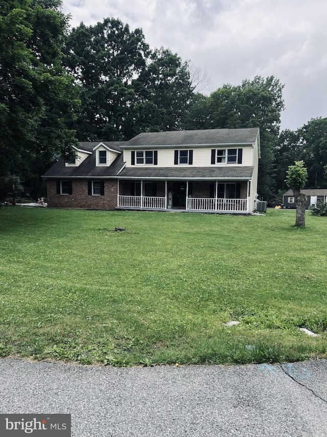 6492 Burning Tree Ter, Fayetteville, PA 17222 - colonial inspired home with covered porch, a front yard, cooling unit, and view of wooded area