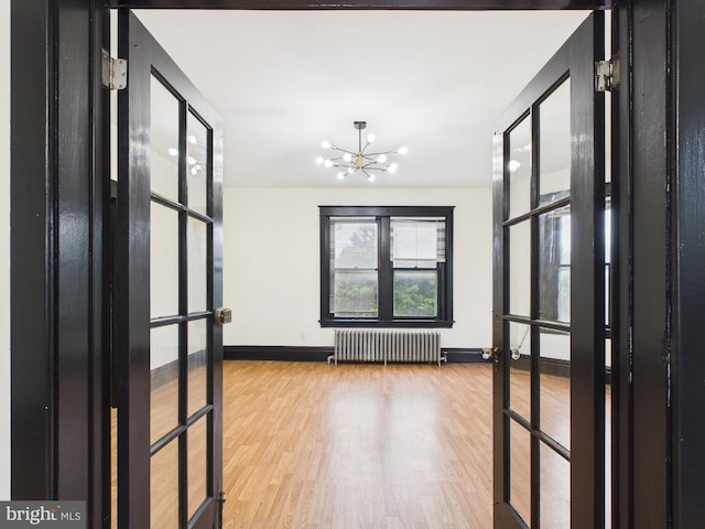 3437 Market St, Camp Hill, PA 17011 - hall with radiator heating unit, a chandelier, wood finished floors, and french doors