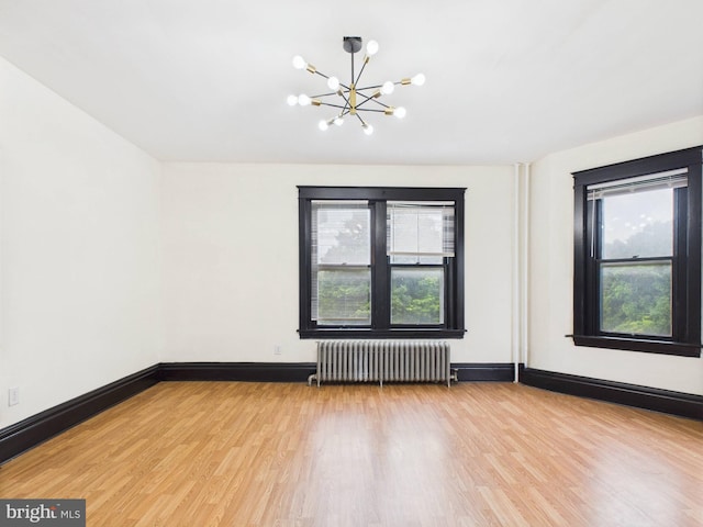 3437 Market St, Camp Hill, PA 17011 - unfurnished room featuring radiator heating unit, a chandelier, and light wood-type flooring