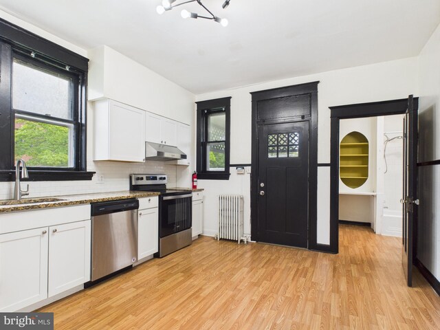 3437 Market St, Camp Hill, PA 17011 - kitchen with appliances with stainless steel finishes, radiator, under cabinet range hood, light wood-style flooring, and tasteful backsplash