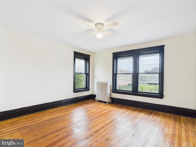 3437 Market St, Camp Hill, PA 17011 - spare room featuring radiator heating unit, ceiling fan, and hardwood / wood-style floors