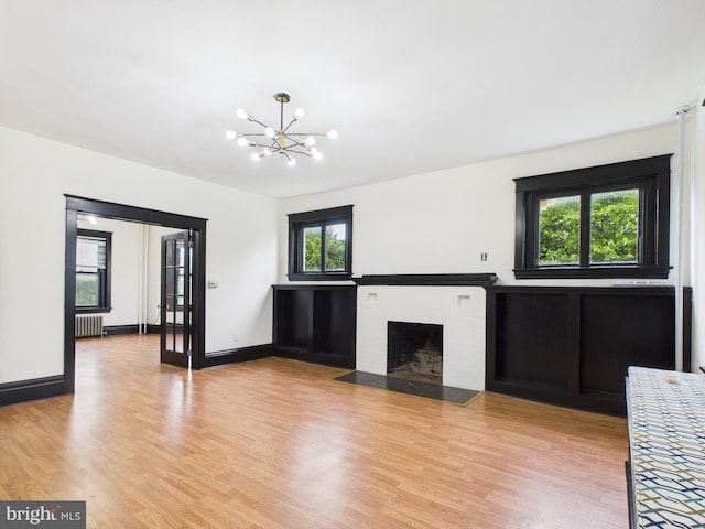 3437 Market St, Camp Hill, PA 17011 - unfurnished living room featuring radiator heating unit, a chandelier, light wood finished floors, and a fireplace