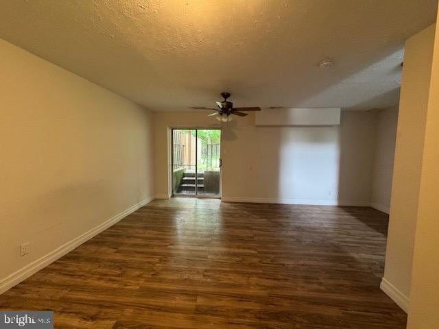 7849 Hidden Crk Unit 24, Baltimore, MD 21226 - spare room featuring dark wood finished floors, baseboards, ceiling fan, and a textured ceiling
