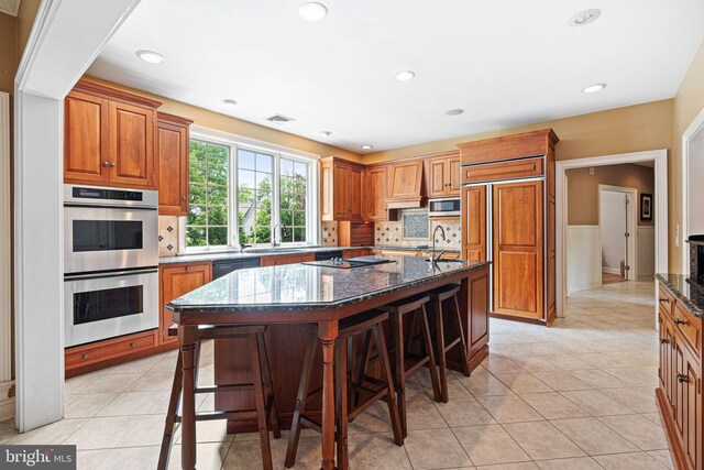 1214 Hunt Seat Dr, Lower Gwynedd, PA 19002 - kitchen with black appliances, a breakfast bar area, dark stone countertops, tasteful backsplash, and recessed lighting