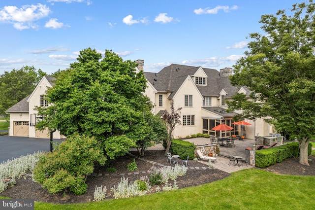 1214 Hunt Seat Dr, Lower Gwynedd, PA 19002 - back of property with stucco siding, a chimney, a patio, and a garage