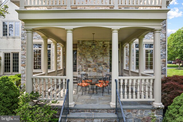 1214 Hunt Seat Dr, Lower Gwynedd, PA 19002 - view of exterior entry with stone siding, covered porch, and outdoor dining space