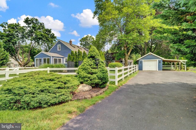 10 Shaw Dr, Kingston, NJ 08528 - view of front of home with asphalt driveway, a detached garage, a chimney, and an outdoor structure