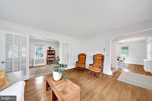 10 Shaw Dr, Kingston, NJ 08528 - living area with radiator, arched walkways, wood finished floors, and french doors