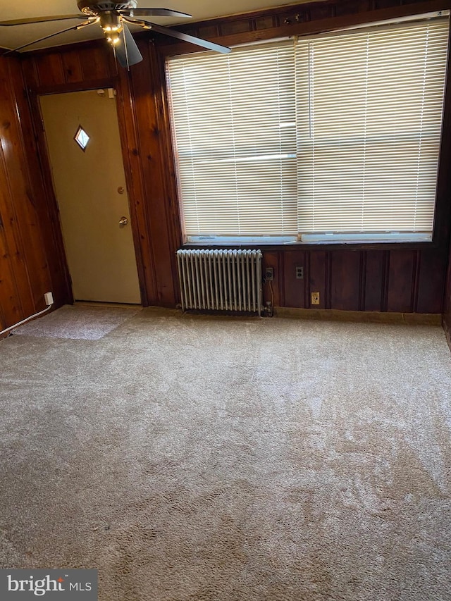 1642 Rosedale St NE, Washington, DC 20002 - spare room featuring radiator heating unit, carpet flooring, a ceiling fan, and wooden walls