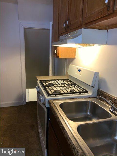 1642 Rosedale St NE, Washington, DC 20002 - kitchen with white gas range, under cabinet range hood, and dark tile patterned floors