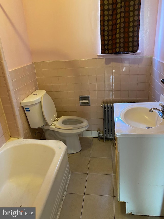 1642 Rosedale St NE, Washington, DC 20002 - bathroom featuring radiator heating unit, tile walls, a tub to relax in, tile patterned flooring, and vanity