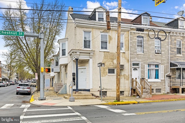 1101 Chestnut St, Reading, PA 19602 - townhome / multi-family property featuring a chimney, cooling unit, and stucco siding